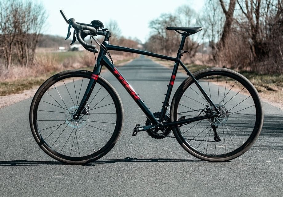 black gravel bike with red lettering parked in the middle of the road