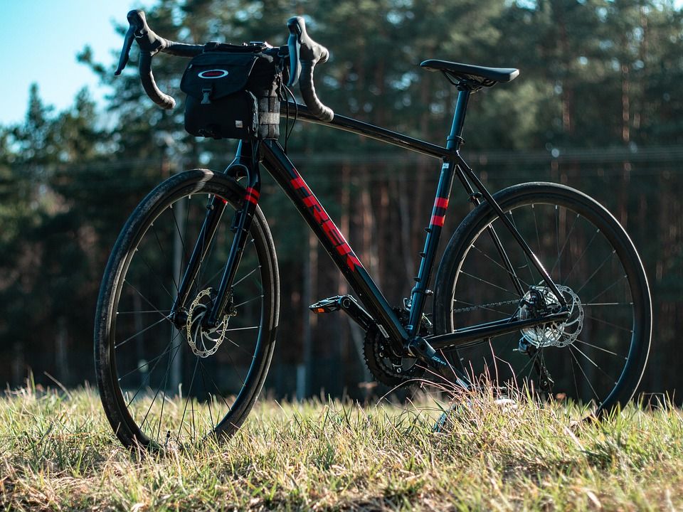 black gravel bike with red lettering parked on a grass field