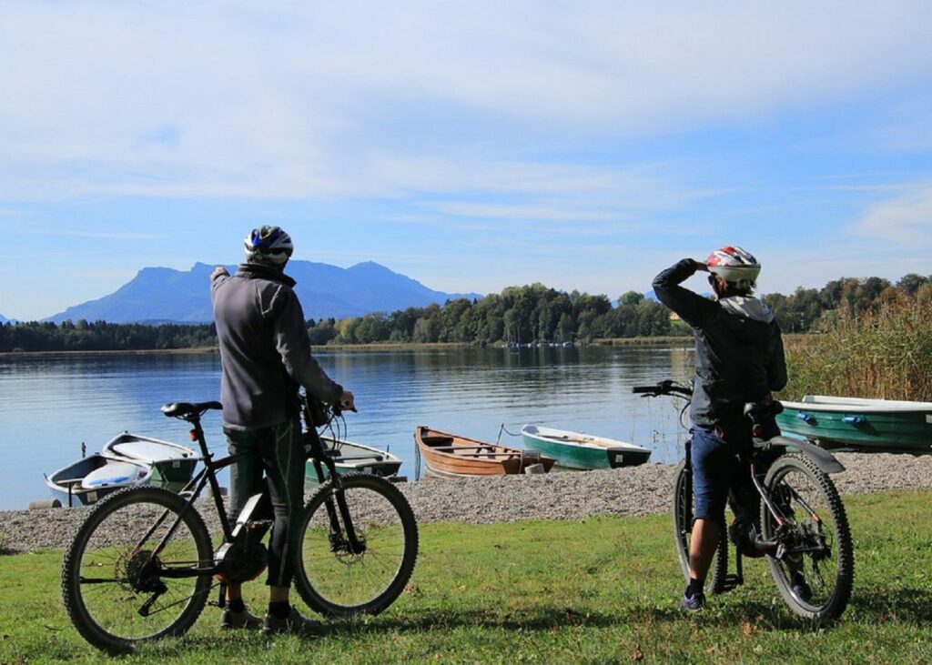 two senior citizen enjoying the lake shore view during bicycle ride