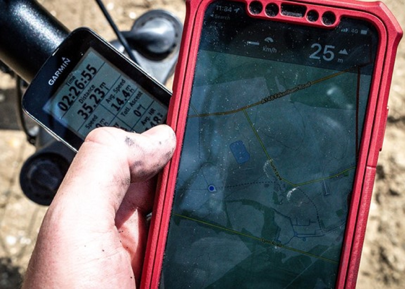 a hand holding a cell phone and a gps device
