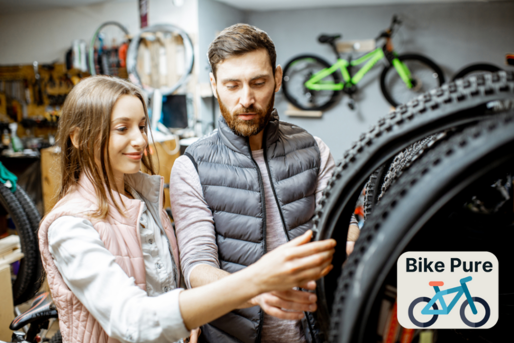 A picture of a couple in a bicycle specialty shop choosing a bike tire
