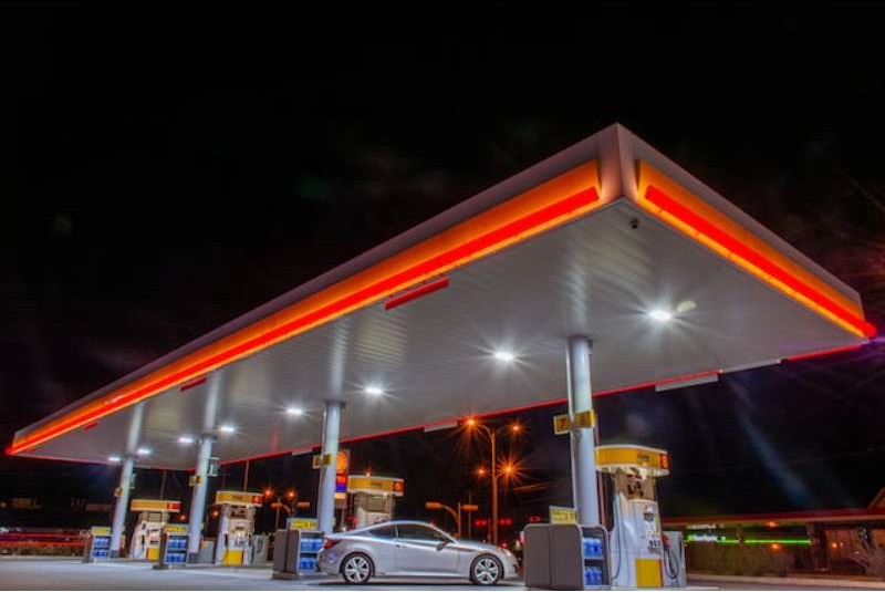 a gas station at night with a car parked in front