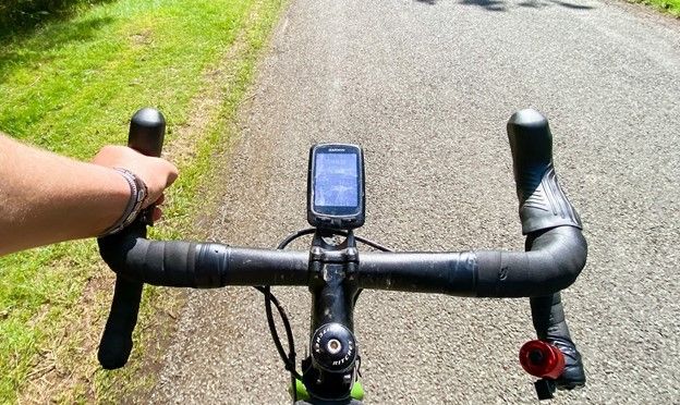 A close view image of a bike handlebar with a device at the middle