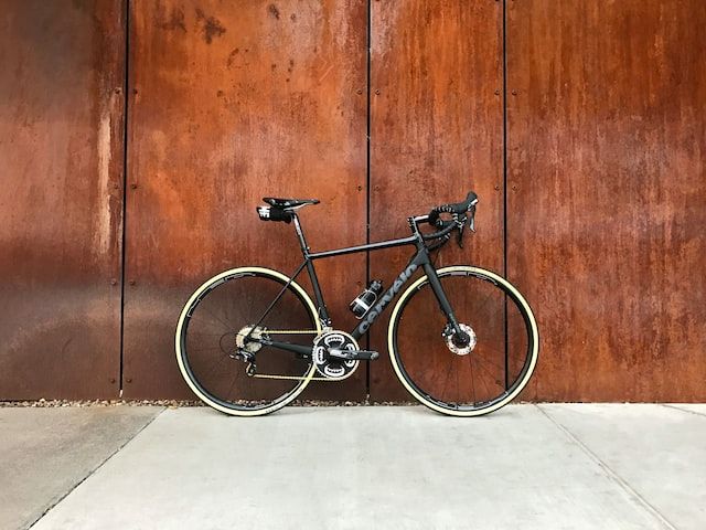 Black bike by a rusty wall