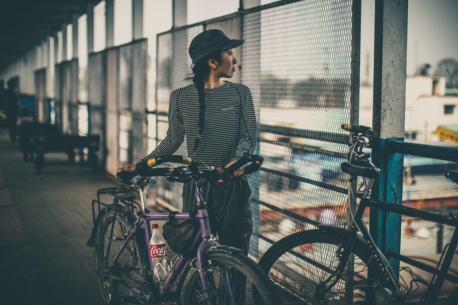 a person standing next to their bike at a train station