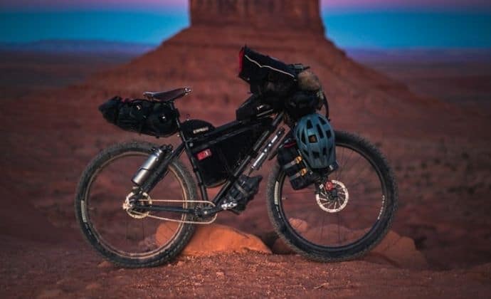 a bike is parked in front of a rock formation loaded with bags