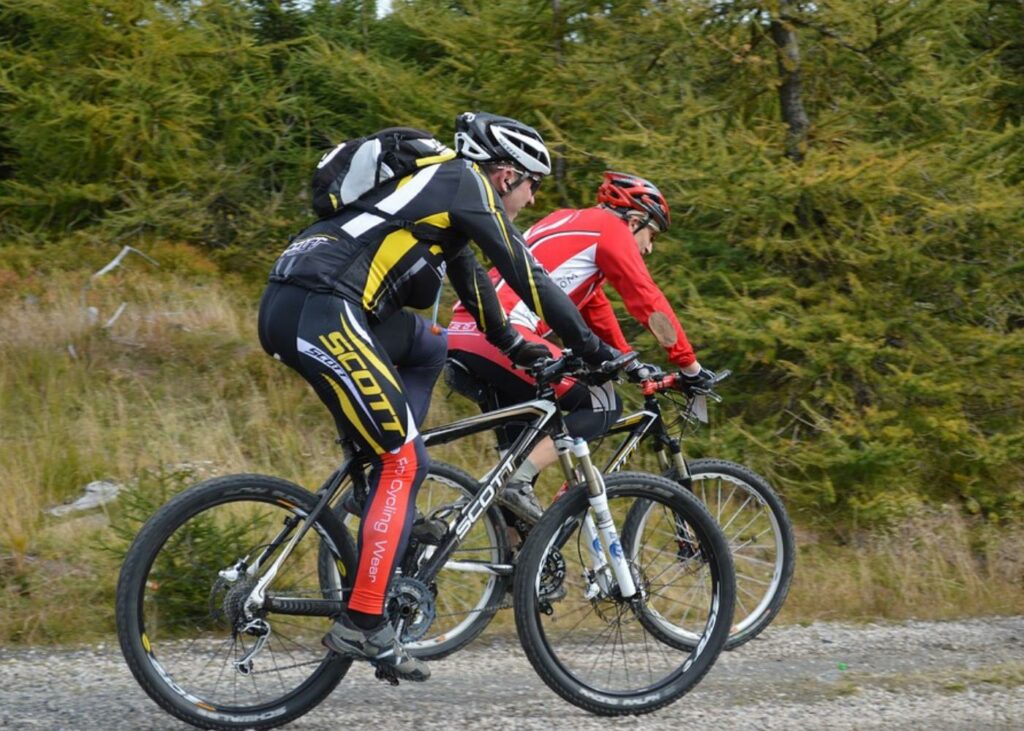 Two male cyclists navigating a trail on their mountain bikes.