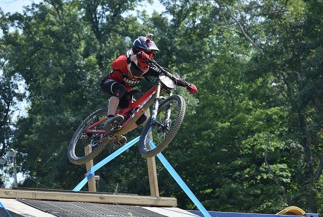 a person on a mountain bike doing a trick on a ramp